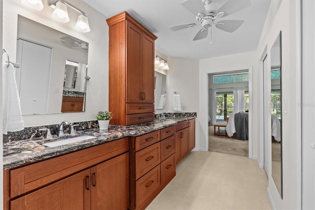 full bath with a sink, a ceiling fan, double vanity, and ensuite bathroom