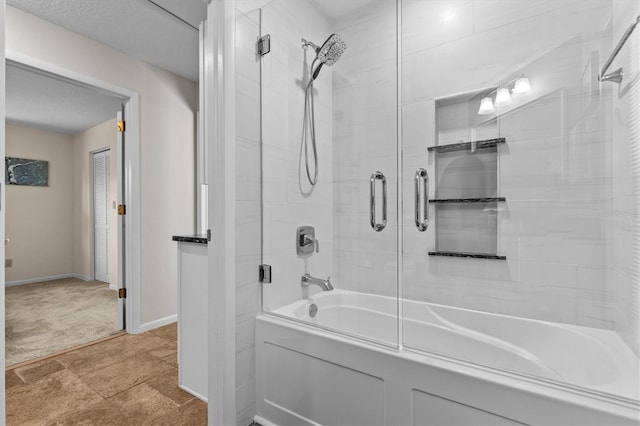 bathroom with baseboards, enclosed tub / shower combo, and stone finish floor