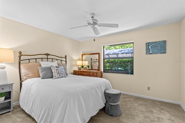 carpeted bedroom featuring baseboards, a textured ceiling, and ceiling fan
