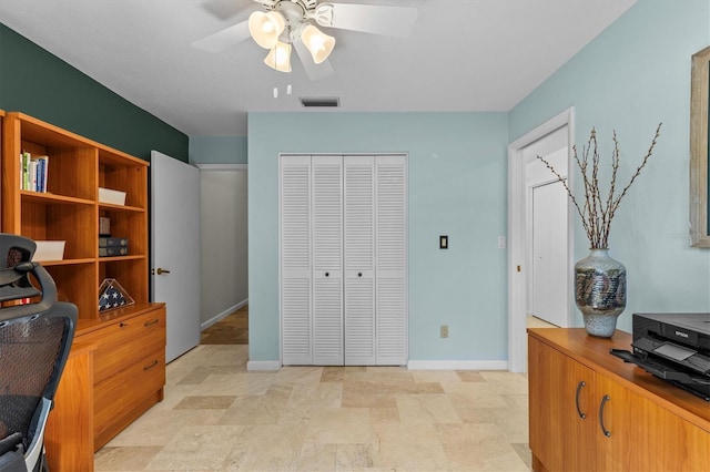 office area with visible vents, stone finish floor, baseboards, and ceiling fan
