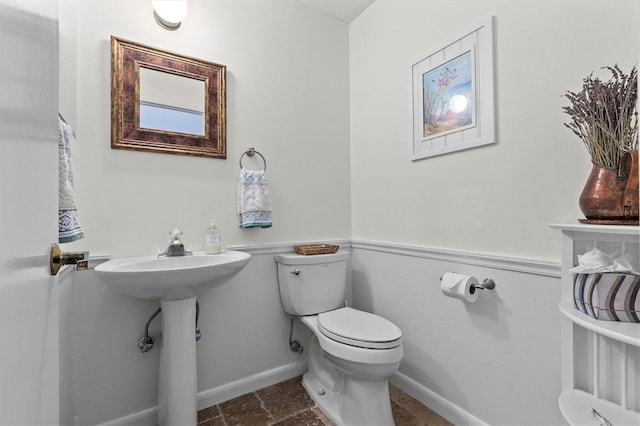 bathroom with toilet and baseboards