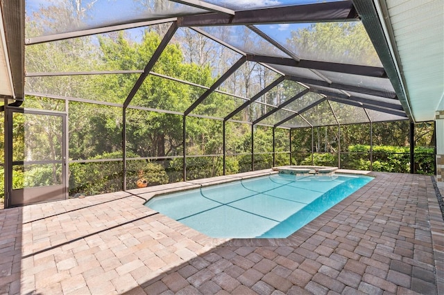 view of pool with a patio area, a pool with connected hot tub, and a lanai