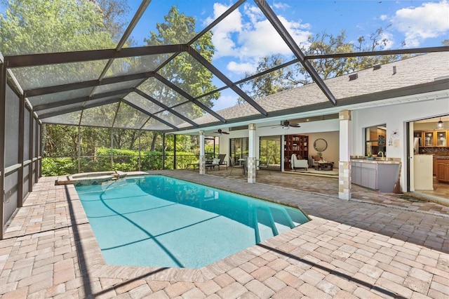 view of pool with exterior kitchen, a patio area, a pool with connected hot tub, and ceiling fan