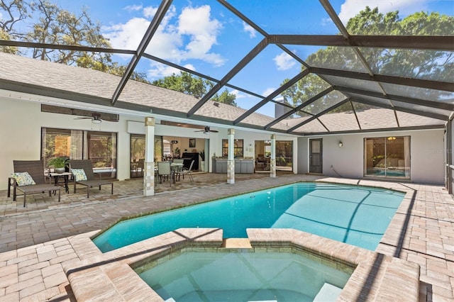 view of swimming pool featuring a lanai, ceiling fan, a pool with connected hot tub, and a patio