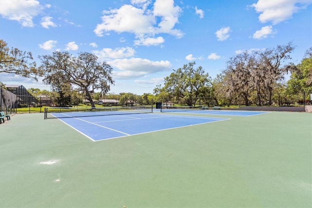 view of tennis court featuring community basketball court and fence