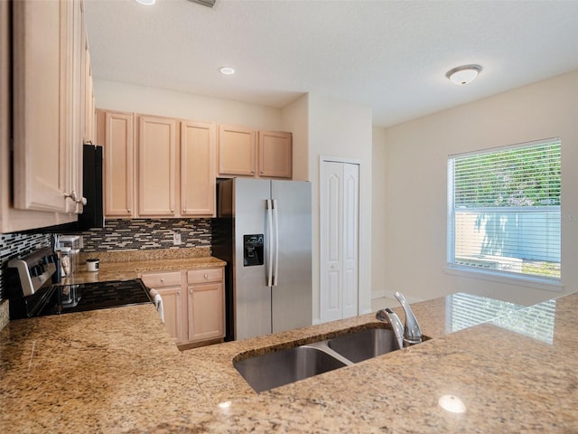 405 Laguna Mill Dr, Ruskin, FL 33570 - kitchen with appliances with stainless steel finishes, light stone counters, backsplash, and light brown cabinets