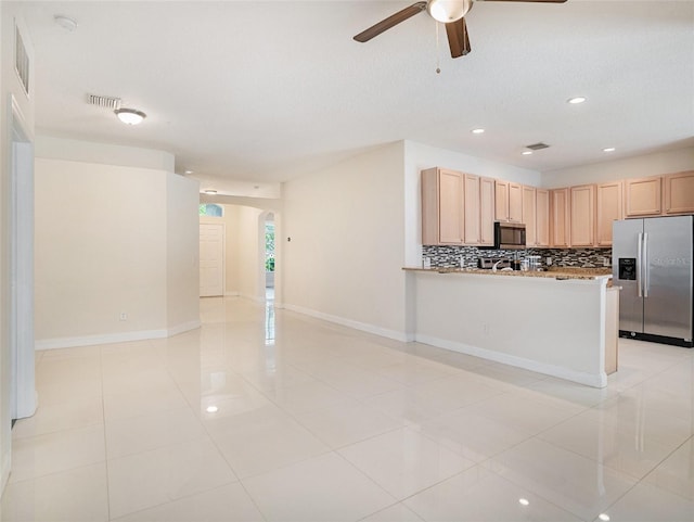 405 Laguna Mill Dr, Ruskin, FL 33570 - kitchen featuring appliances with stainless steel finishes, arched walkways, a ceiling fan, tasteful backsplash, and open floor plan