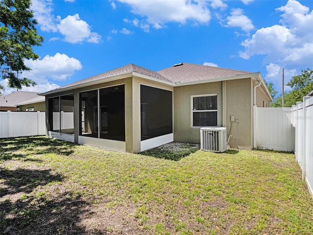 405 Laguna Mill Dr, Ruskin, FL 33570 - back of property with a sunroom, a fenced backyard, stucco siding, and a shingled roof