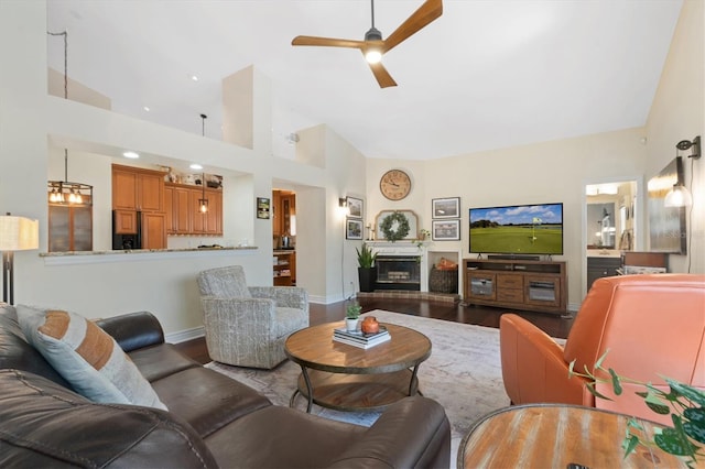 17503 Edinburgh Dr, Tampa, FL 33647 - living area with wood finished floors, a ceiling fan, baseboards, high vaulted ceiling, and a glass covered fireplace