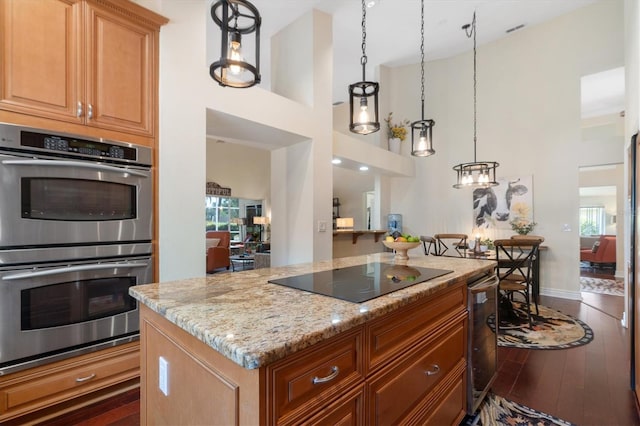 17503 Edinburgh Dr, Tampa, FL 33647 - kitchen featuring a center island, light stone countertops, wood finished floors, stainless steel double oven, and black electric cooktop
