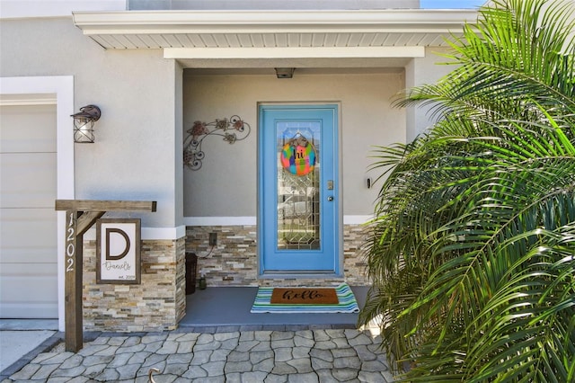 view of exterior entry with stone siding and stucco siding