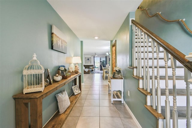 hallway featuring tile patterned flooring, stairway, and baseboards