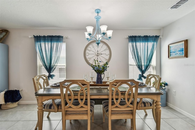 dining room with visible vents, baseboards, light tile patterned flooring, a notable chandelier, and a textured ceiling