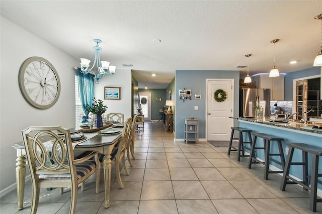 dining area with light tile patterned floors, visible vents, baseboards, a textured ceiling, and a chandelier