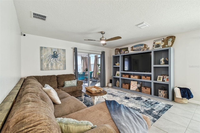 living room with visible vents, a textured ceiling, a ceiling fan, and tile patterned flooring