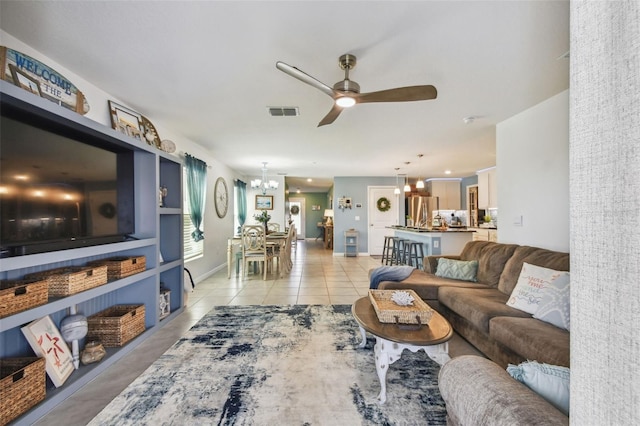 living room with visible vents, baseboards, light tile patterned flooring, and ceiling fan with notable chandelier