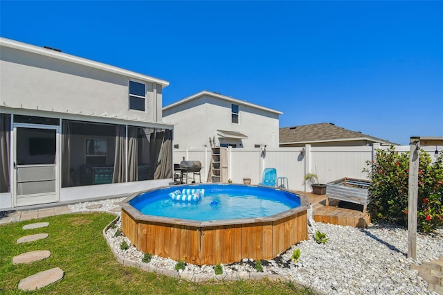 view of swimming pool featuring area for grilling, a jacuzzi, a sunroom, and fence