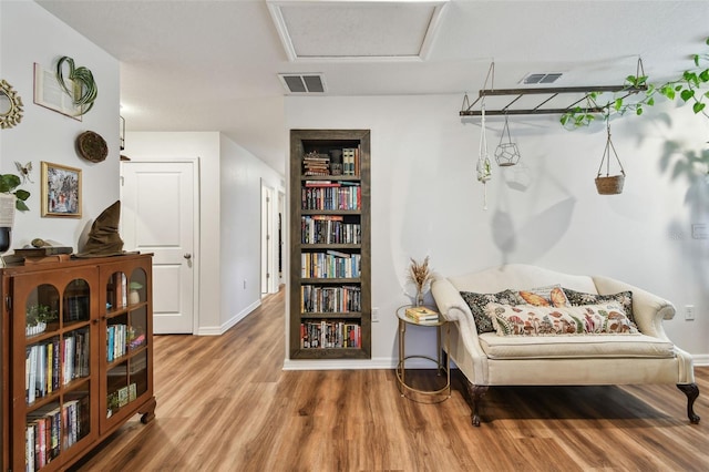 sitting room with visible vents, baseboards, and wood finished floors