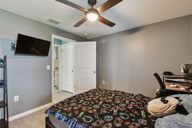 bedroom featuring visible vents, baseboards, ceiling fan, light carpet, and a textured ceiling