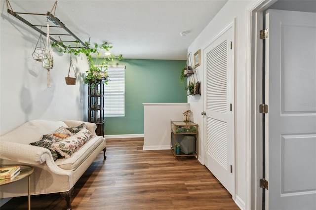 sitting room with baseboards and wood finished floors