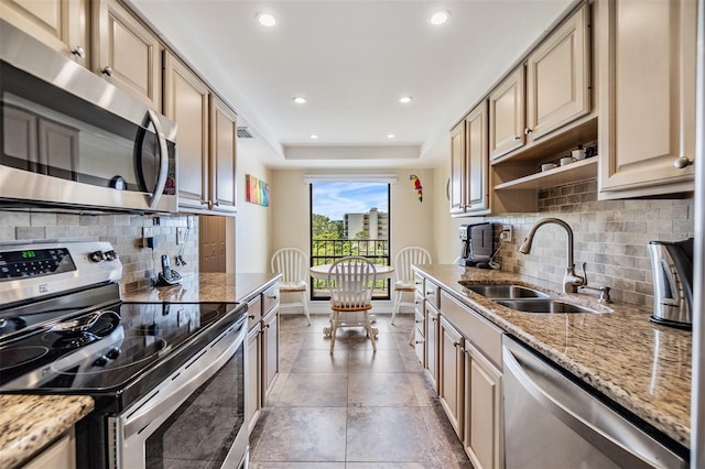 kitchen with a sink, recessed lighting, appliances with stainless steel finishes, baseboards, and light stone countertops
