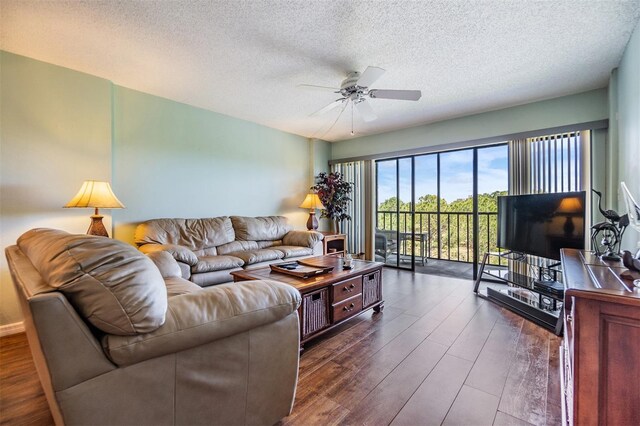living room with a textured ceiling, ceiling fan, and dark wood-style flooring