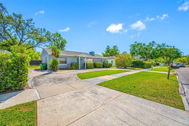 3310 W Swann Ave, Tampa, FL 33609 - ranch-style home with a front yard, concrete driveway, and stucco siding