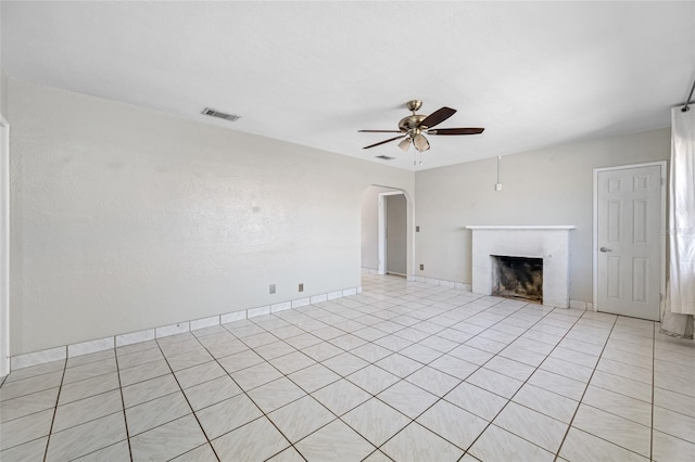 3310 W Swann Ave, Tampa, FL 33609 - unfurnished living room with visible vents, baseboards, a fireplace, arched walkways, and a ceiling fan