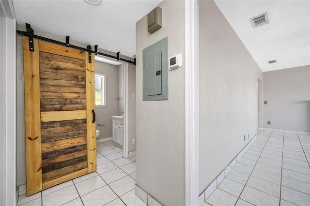 3310 W Swann Ave, Tampa, FL 33609 - hall with electric panel, visible vents, a barn door, and light tile patterned flooring