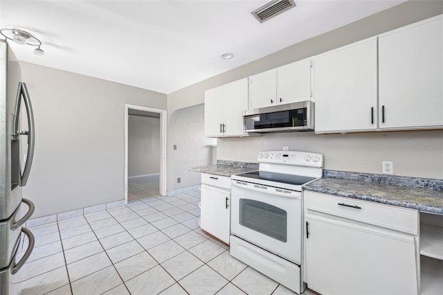 3310 W Swann Ave, Tampa, FL 33609 - kitchen featuring light tile patterned flooring, visible vents, white cabinets, and appliances with stainless steel finishes
