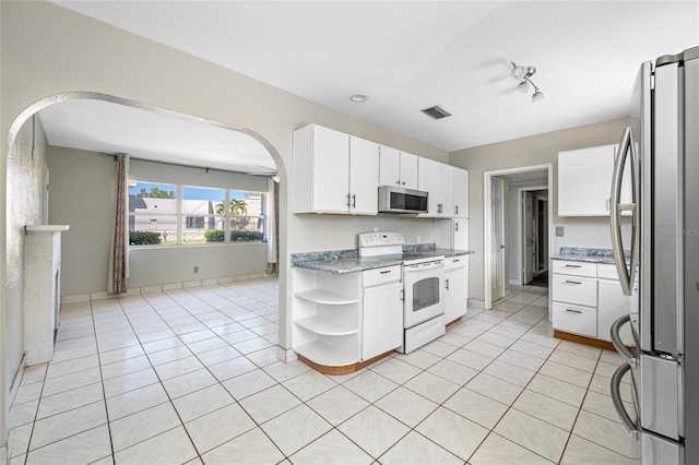 3310 W Swann Ave, Tampa, FL 33609 - kitchen with visible vents, open shelves, arched walkways, stainless steel appliances, and white cabinets