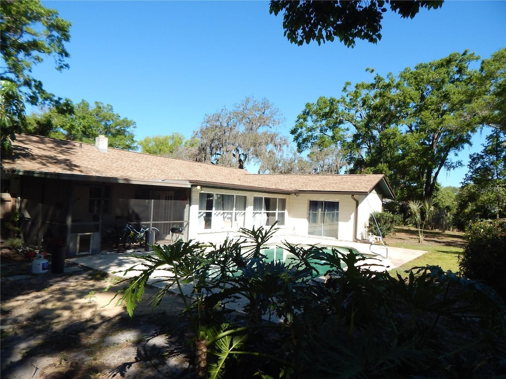 rear view of house featuring a sunroom