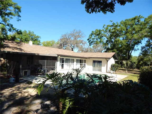 rear view of house featuring a sunroom