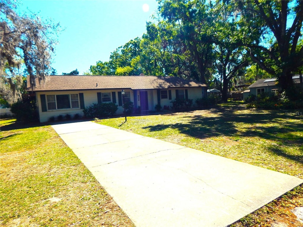 single story home featuring driveway and a front yard
