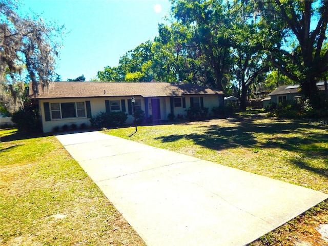 single story home featuring driveway and a front yard