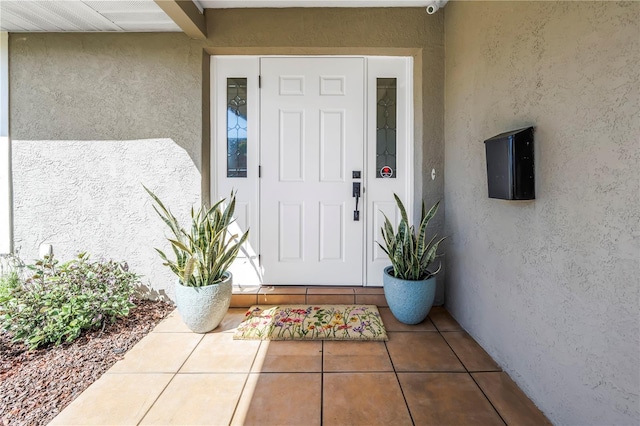 view of exterior entry featuring stucco siding