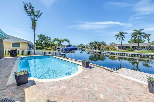 pool with a patio, fence, and a water view