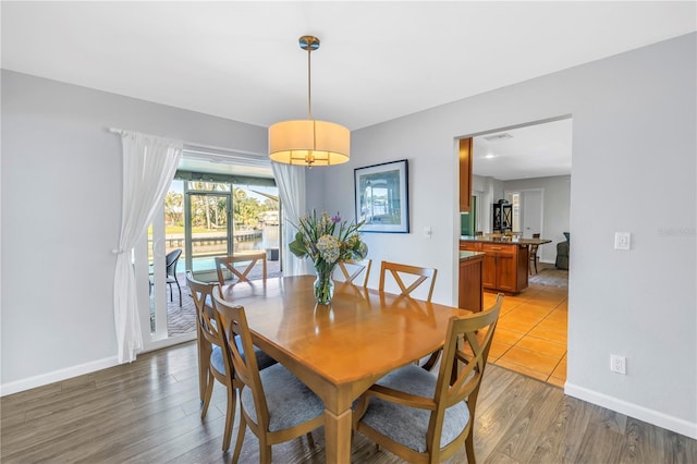 dining room featuring visible vents, baseboards, and light wood-style floors