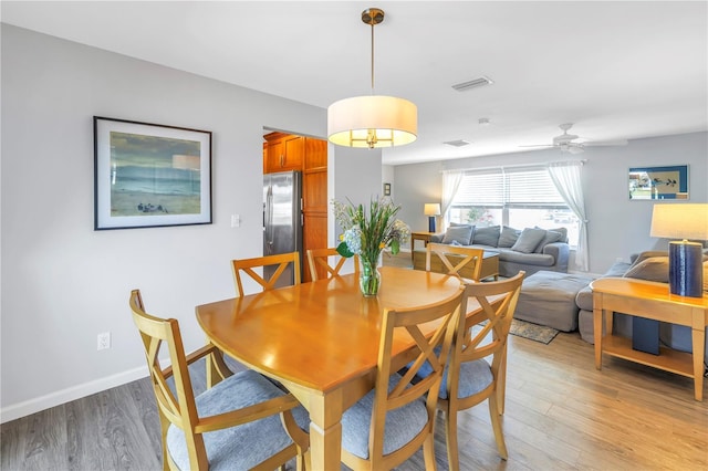 dining area with visible vents, baseboards, light wood-style floors, and a ceiling fan