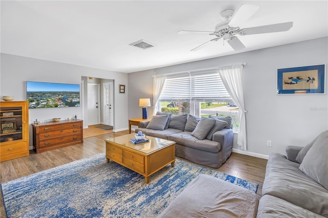 living room featuring visible vents, baseboards, ceiling fan, and wood finished floors