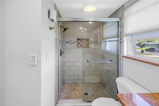 bathroom with a shower stall and toilet