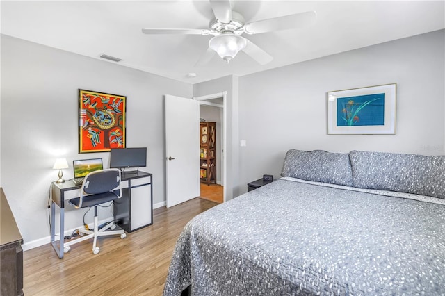 bedroom with visible vents, a ceiling fan, baseboards, and wood finished floors