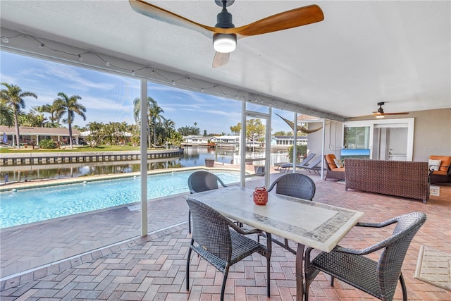 sunroom featuring a water view
