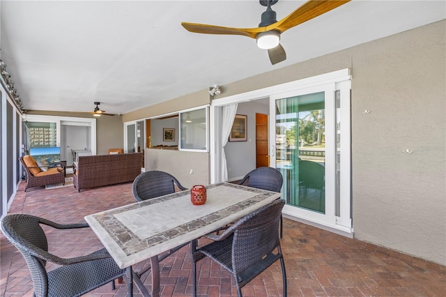 sunroom / solarium with outdoor dining area, outdoor lounge area, and a ceiling fan