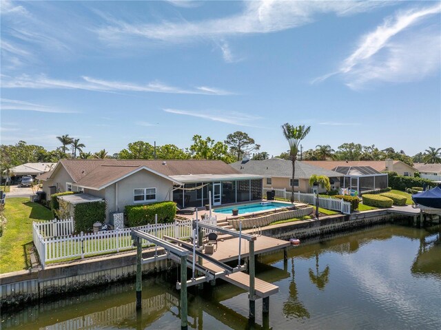 dock area with a fenced in pool, a fenced backyard, a water view, and boat lift
