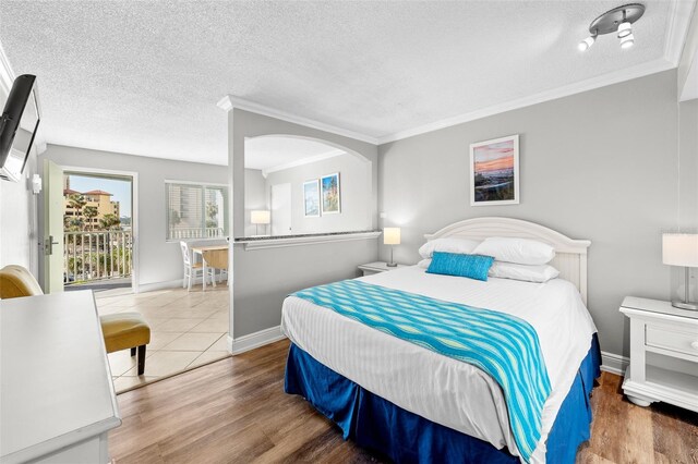 bedroom with wood finished floors, baseboards, and a textured ceiling