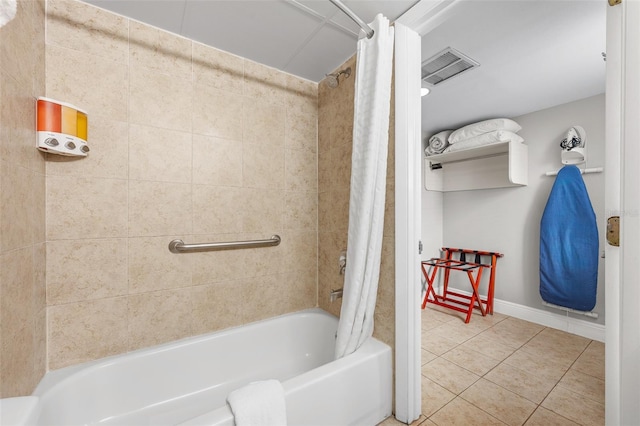 bathroom featuring tile patterned floors, visible vents, baseboards, and shower / bath combo