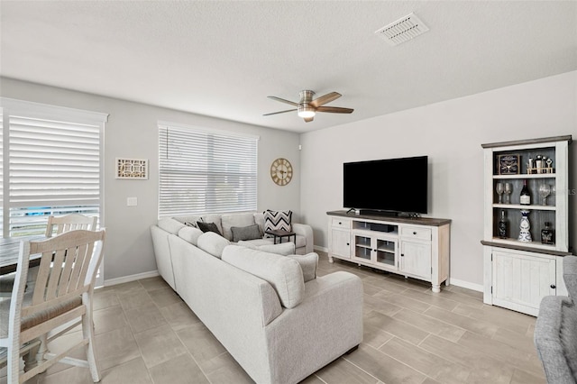 2760 Scarlet Bay Pl, Brandon, FL 33510 - living area featuring visible vents, baseboards, a textured ceiling, and ceiling fan