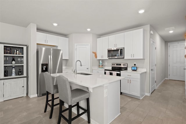 2760 Scarlet Bay Pl, Brandon, FL 33510 - kitchen featuring a breakfast bar, a sink, white cabinetry, appliances with stainless steel finishes, and light countertops