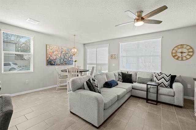 2760 Scarlet Bay Pl, Brandon, FL 33510 - living room with baseboards, visible vents, a textured ceiling, ceiling fan with notable chandelier, and light wood-type flooring